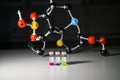 Three colourful solution in different LCMS glass vial on a white bench with molecular model background for biomedical research Royalty Free Stock Photo