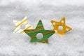 Three colourful wooden Christmas stars in the snow