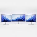 Three computer monitors displaying mountain scene, isolated on white background Royalty Free Stock Photo