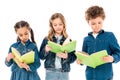Three concentrated kids in denim clothes reading books isolated on white.