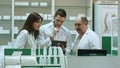Three concentrated pharmacists using tablet computer at a counter in a pharmacy