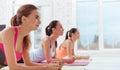 Three concentrated women doing a plank in gym