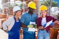 Three concentrated workers are discussing work issues at the warehouse