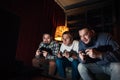 Three concentrated young guy play home video game Royalty Free Stock Photo