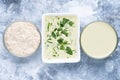 Three condiment bowls with mayonnaise on blue background