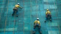 Three Construction Workers Ascending a Building with Safety Gear Royalty Free Stock Photo
