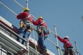 Construction workers in safety gear installing scaffolding Royalty Free Stock Photo