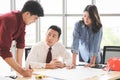 Construction workers , a female architect and two male engineers discussing about the project at office table indoor Royalty Free Stock Photo