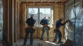 Three Construction Workers Installing Insulation in a New House Royalty Free Stock Photo