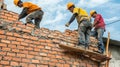 Three Construction Workers Laying Bricks on a Wall Royalty Free Stock Photo