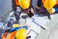 Three construction workers sitting on concrete and discussing