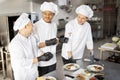 Cooks with different nationalties tasting cooked meals for restaurant menu Royalty Free Stock Photo