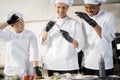 Cooks with different nationalties tasting cooked meals for restaurant menu Royalty Free Stock Photo