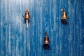 Three copper old vintage bells, doorbell, rope on a wooden blue aged wall. Concept decor element in interior of deck, cabin of Royalty Free Stock Photo