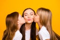 Three coquette ladies two daughters kissing mommy cheekbones wear casual white t-shirts isolated yellow background