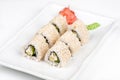 Three-cornered sushi roll with fish, cucumber and green salad. Royalty Free Stock Photo