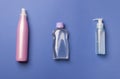 Three cosmetic bottles on blue colored paper bsckground Royalty Free Stock Photo