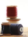 Three cotton reels close up on a table with a white background