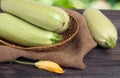 Three courgettes with a flower on sackcloth wooden background Royalty Free Stock Photo