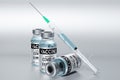 Three covid-19 / SARS-CoV-2 / coronavirus vaccine ampoules and syringe