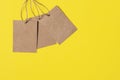 Three Craft brown paper tags isolated on bright yellow background. Sale or price banner with copy space in minimal style Royalty Free Stock Photo