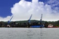 Three crane unloading coal from two barge