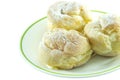 Three cream puffs on white plate closeup