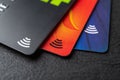 Three credit cards with contactless pay technology on a black background macro. Debit cards for money cash withdrawals. Payment