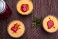 Three creme brulee desserts on a brown tablecloth next to a berry drink Royalty Free Stock Photo