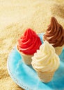 Three cripsy wafer cones with ice cream on sand