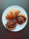 Three croissants on white plate Royalty Free Stock Photo