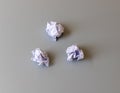 Three crumpled paper balls on a light gray background