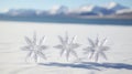 Three crystal snowflakes on the white snow with mountains in the background