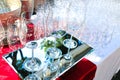 three crystal wine glasses on mirrored surface with many glasses behind. catering service. Wine tasting preparation