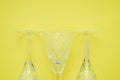Three crystal wine glasses on a yellow background