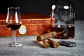 Three Cuban cigars on a stone table with a lighter and a wooden humidor with a glass and a bottle of Whiskey Royalty Free Stock Photo