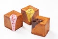 Three cube shaped croissants with creamy berry glaze, pistachio sauce and chocolate ganache
