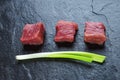 Three cubes of meat and green onions