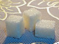 Three cubes of sugar. Close-up on sugar. Texture of dry sugar. White sugar
