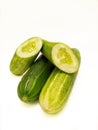 Three cucumbers stacked on isolated white background, two whole cucumbers and and cucumber cut in half, fresh green cucumber Royalty Free Stock Photo