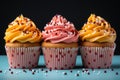 three cupcakes with frosting on a blue background