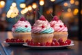 three cupcakes with frosting and cherries on a table