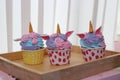 Three cupcakes in line on wooden tray