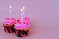 Three cupcakes with pink frosting and a single candle on each Royalty Free Stock Photo