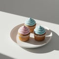 Three cupcakes are placed on a round white plate. Each cupcake has a swirl of pastel Royalty Free Stock Photo