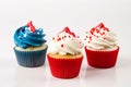 Three cupcakes with red, white and blue frosting. AI generative image.