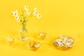 Three cups of camomile tea, transparent teapot and vase with daisy-like flowers on yellow background. Chamomile Tea Benefits Your Royalty Free Stock Photo