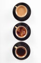 Three cups of coffee with black, white and flowing milk