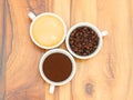 Three cups with coffee, coffee beans and ground coffee