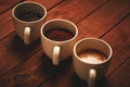 Three cups of espresso, freshly ground coffee and coffee beans Royalty Free Stock Photo